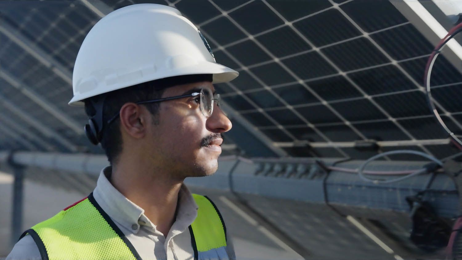 Mohammed walks alongside solar panels, part of the 760,000 500 photovoltaic panels powering the destination sustainably.
