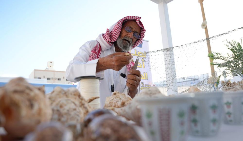 A fisherman mends his nets at Souq Amerah.